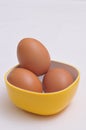 Three chicken eggs in a yellow bowl telur ayam Royalty Free Stock Photo